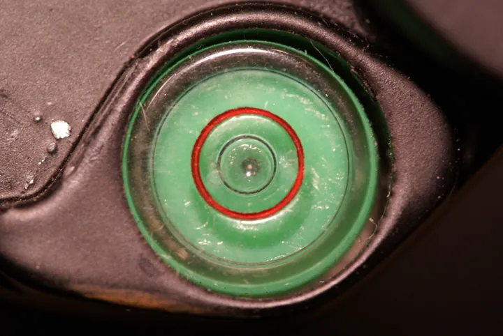 Photo d’origine : Niveau à bulle circulaire dont la bulle centrée dans le cercle rouge indique que tout est d'aplomb.