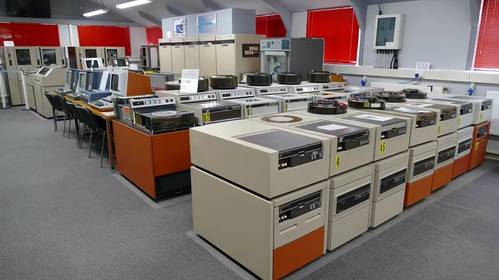 Photo d’origine : Salle d’ordinateurs anciens, garnie d’unités de disques et de bandes magnétiques alignées.