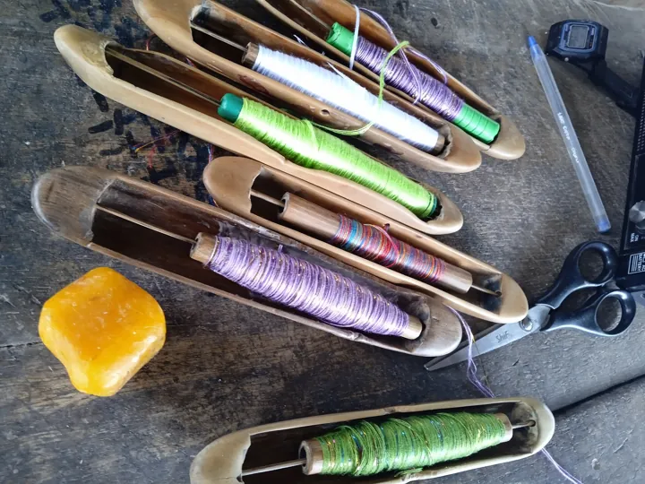 Original photo: Navettes de tissage en bois garnies de fils de couleur, utilisées pour tisser le kente.