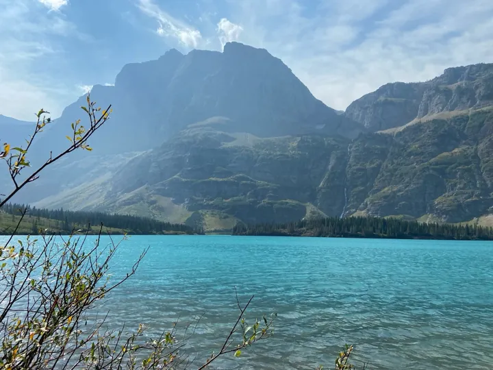 Original photo: Lac d’un bleu turquoise au pied d’un massif rocheux de montagne.