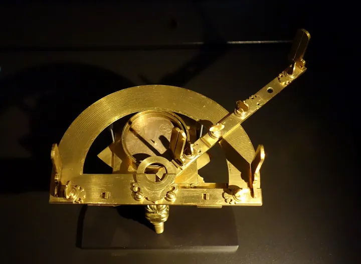 Photo d’origine : Instrument d'arpenteur en laiton pour mesurer les angles : demi-cercle gradué et alidade.